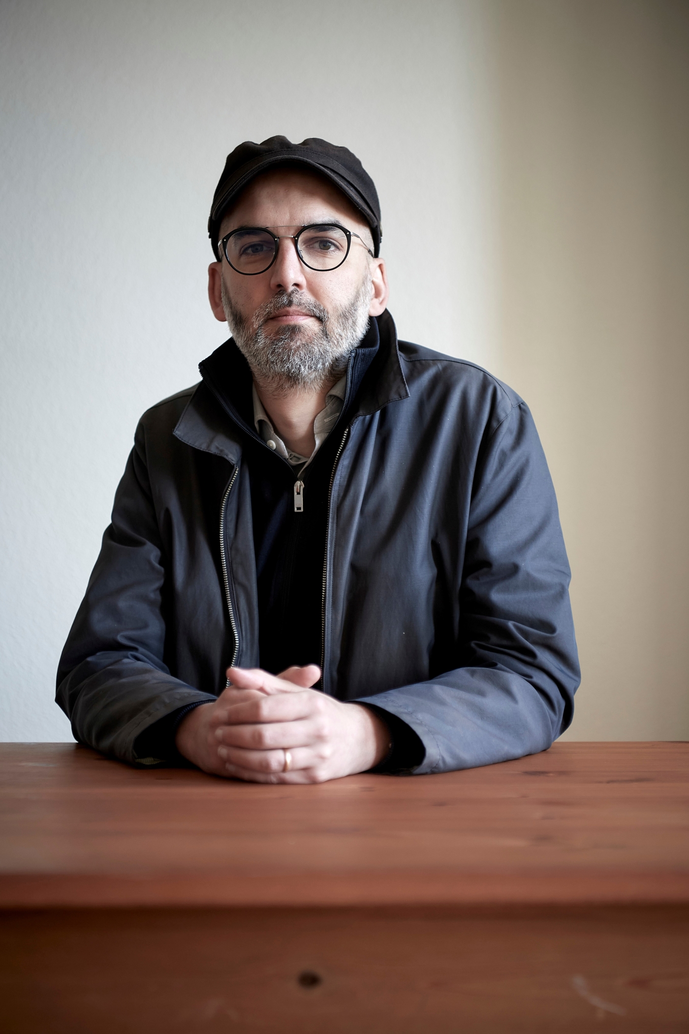 Der Autor Martin Bieri sitzt an einem Tisch und blickt in die Kamera.