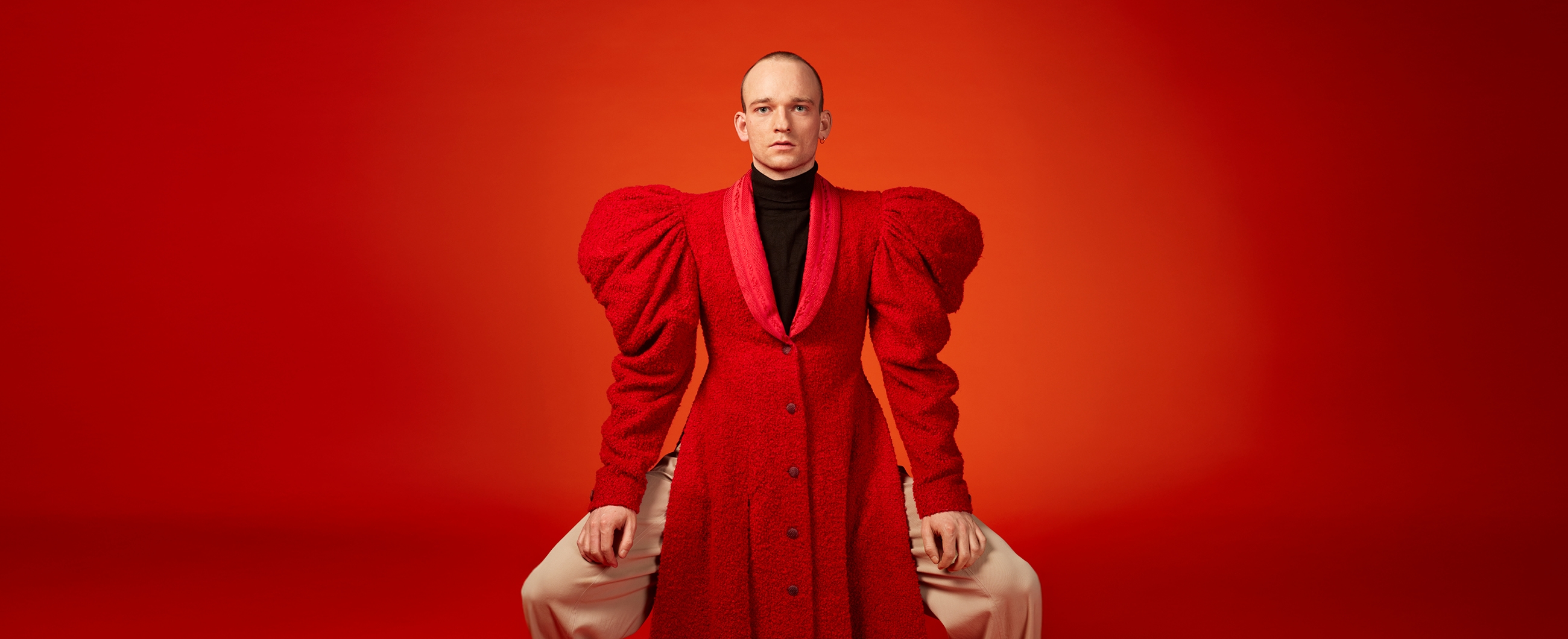 ein junger mann trägt ein grosses, rotes Kleid